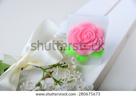 Handmade soap. Cake in the shape of flowers and roses. The branch of white lilac with satin ribbon
