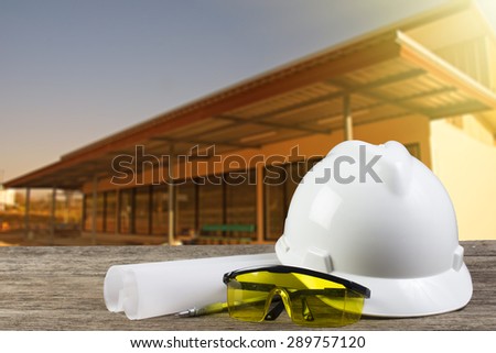 file of safety helmet and architect plant on wood table