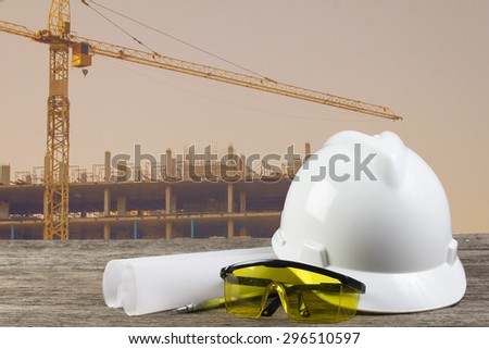 file of safety helmet and architect plant on wood table with  construction,vintage color