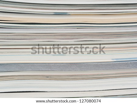 Side view of a stack of paper, books and magazines.