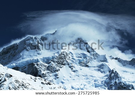 Clouds flow over the summit of Mt Sefton on a blue spring day, Aoraki Mt Cook National Park, New Zealand