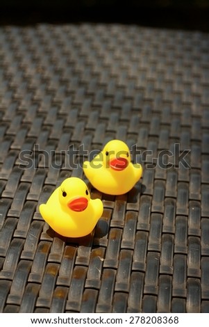 Yellow rubber duck on a background of black wooden.