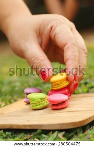 Hand were picked colorful of macaron on a brown tray