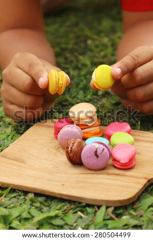 Hand were picked colorful of macaron on a brown tray