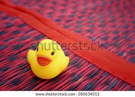 Yellow rubber duck on background of red.