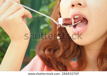 Woman eating chocolate cake at a cafe.