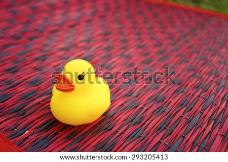 Yellow rubber duck on background of red.