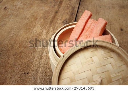 Crab stick in bowl on brown background