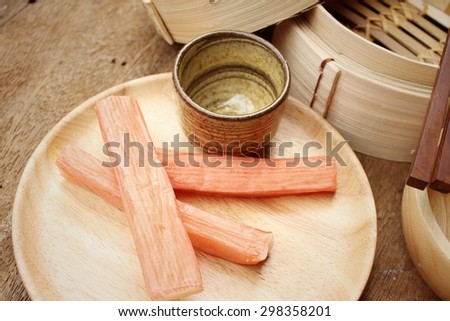 Crab stick in plate on brown background