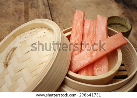 Crab stick in bowl on brown background