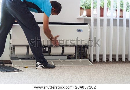 man cleans the air conditioning
