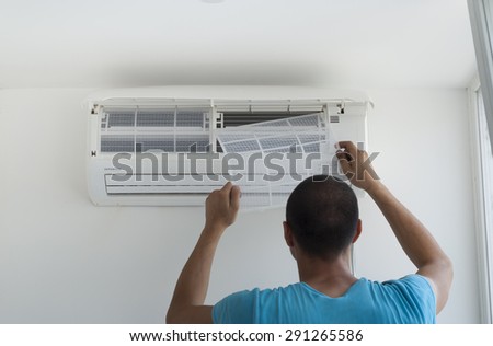 man installs indoor unit of the air conditioner