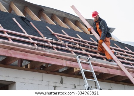 Worker installs bearing laths on the truss system