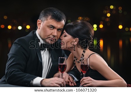 woman and man with wine glasses on night background