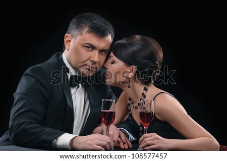 woman and man with wine glasses on black background