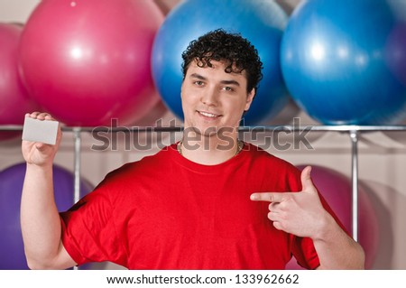 portrait of young man in fitness hall with card