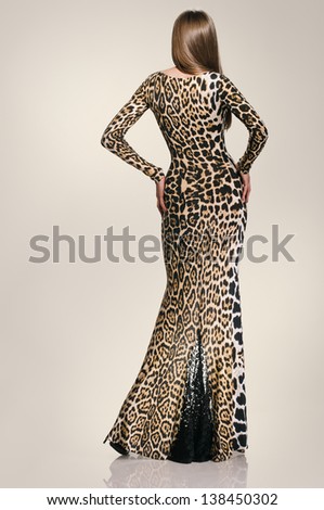 full length beautiful girl in the dress from back on the studio background