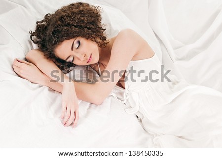 young woman sleeps on the white bed