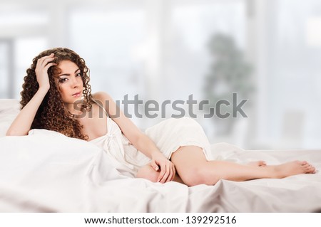 young woman on bed on room background