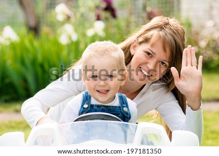 mother with her little son. Outdoors. son with toy car.