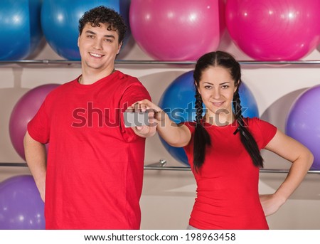 Portrait of happy young couple with standing together in gym. with balls background