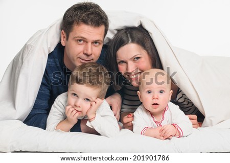 happy family, mother ,father and their baby and boy under the blanket on the bed. on white background