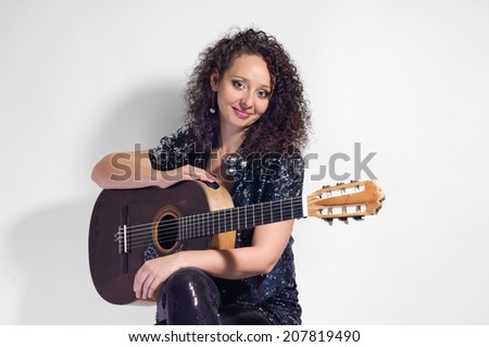 beauty woman player with classical guitar on grey