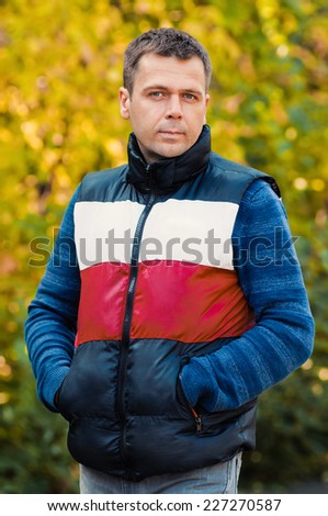 Handsome man in the park. Autumn scenery
