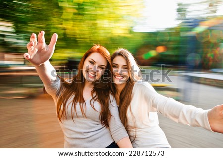 girls friends laughing and outdoor on the carousel girls friends laughing and outdoor on the carousel