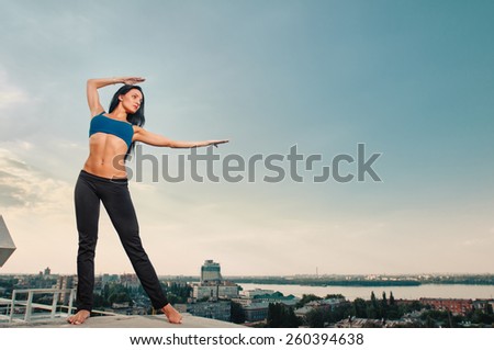 yoga fitness and lifestyle concept - woman doing sports outdoors on the house-top