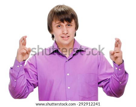 portrait of a young handsome happy man crossing fingers wishing, praying, christening. isolated on white background. Positive emotions facial expression feelings