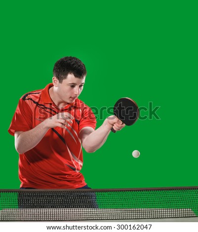 young sports man tennis-player in play on green chroma key studio background