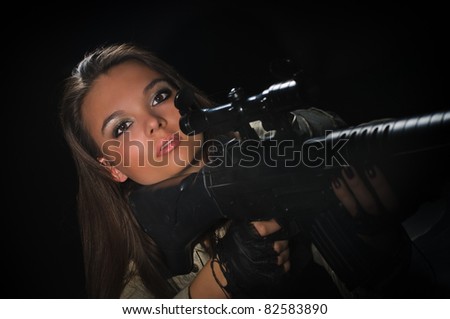 young beauty girl with machine-gun on black background