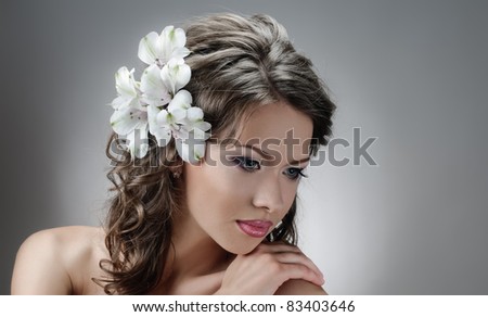 portrait of beautiful bride with flowers in hair on grey