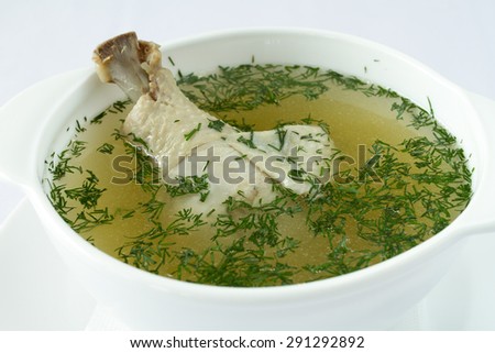 Serving dishes. Chicken soup in a white plate on a white background
