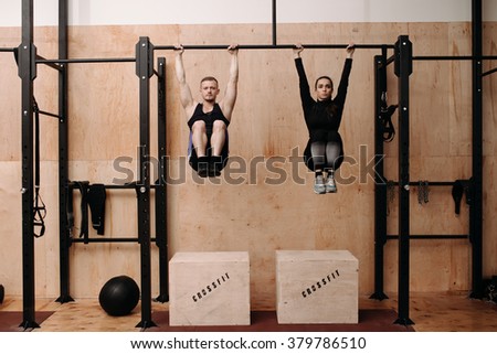 Man and woman doing exercise on horizontal bar