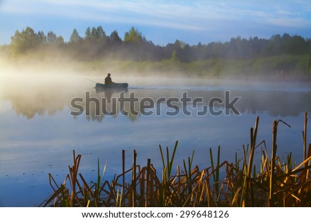 Lone fisherman on the lake early in the morning