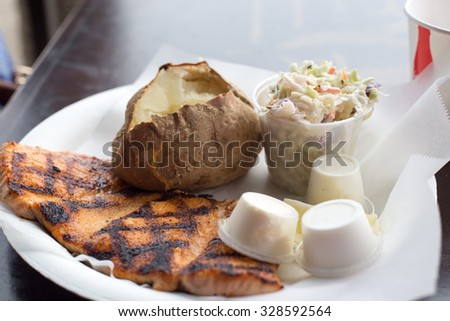 Salmon steak roasted with jacket potato and organic salad vegetables