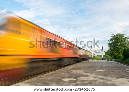 High-speed train that runs through rail track and the countryside of Thailand with motion blur.