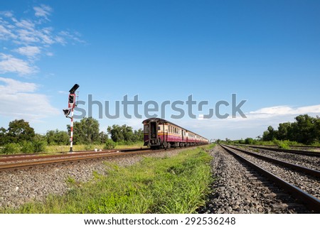 Old train engine and rail track in rural of Thailand with white cloud and blue sky background