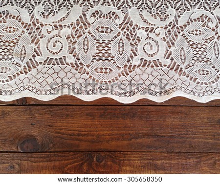Rustic wooden boards with white lace tablecloth