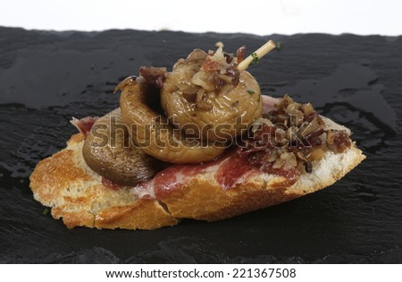 skewer grilled mushrooms with ham on slate plate