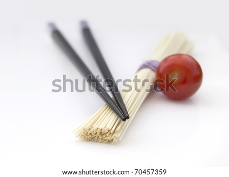 Japan noodles with chopsticks and cherry tomato isolated on light grey