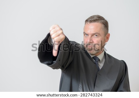 Businessman giving a thumbs down gesture to show he disagrees, a failure or voting down on something, with a stern expression