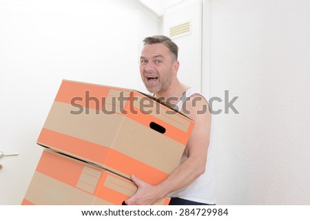 Happy friendly middle-aged man moving home carrying two cardboard cartons packed with his personal belongings