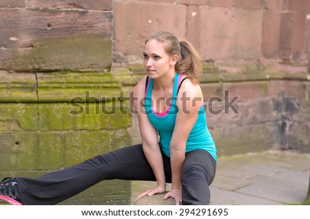 Athletic Young Woman in a Fitness Attire, Balancing her Body on a Bollard While Having an Outdoor Exercise.