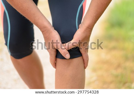 Close up Athletic Woman Holding her Painful Injured Knee While Doing an Outdoor Exercise.