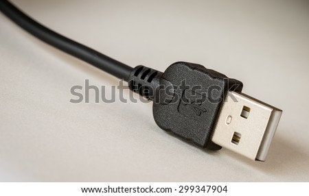 Close up of computer USB plug, with logo and cable.