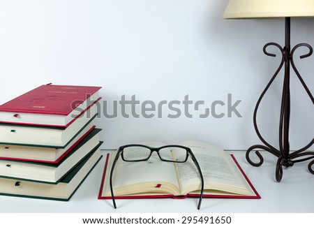 Books on the table, lamp and glasses prepared for reading