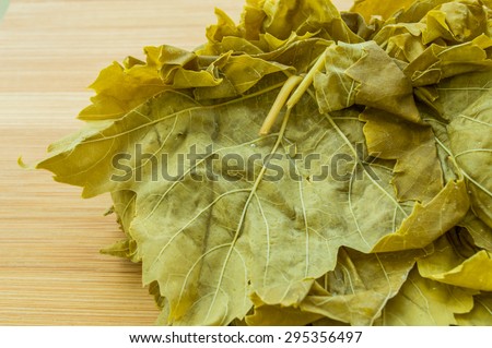 Grape leaves, vine leaves on a wooden chopping board